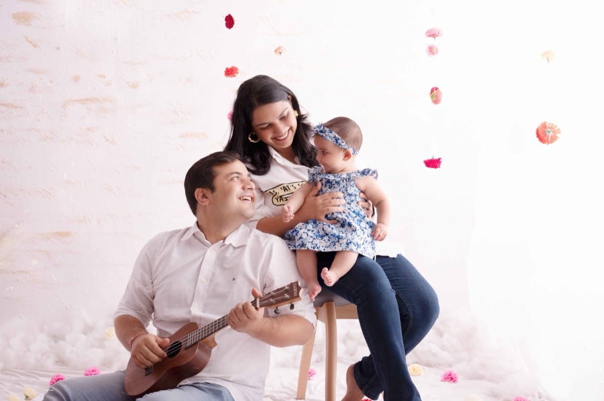 A happy family of four enjoying a lifestyle family photoshoot in a Delhi park, with natural and candid portraits by Priyansh Bhardwaj.
