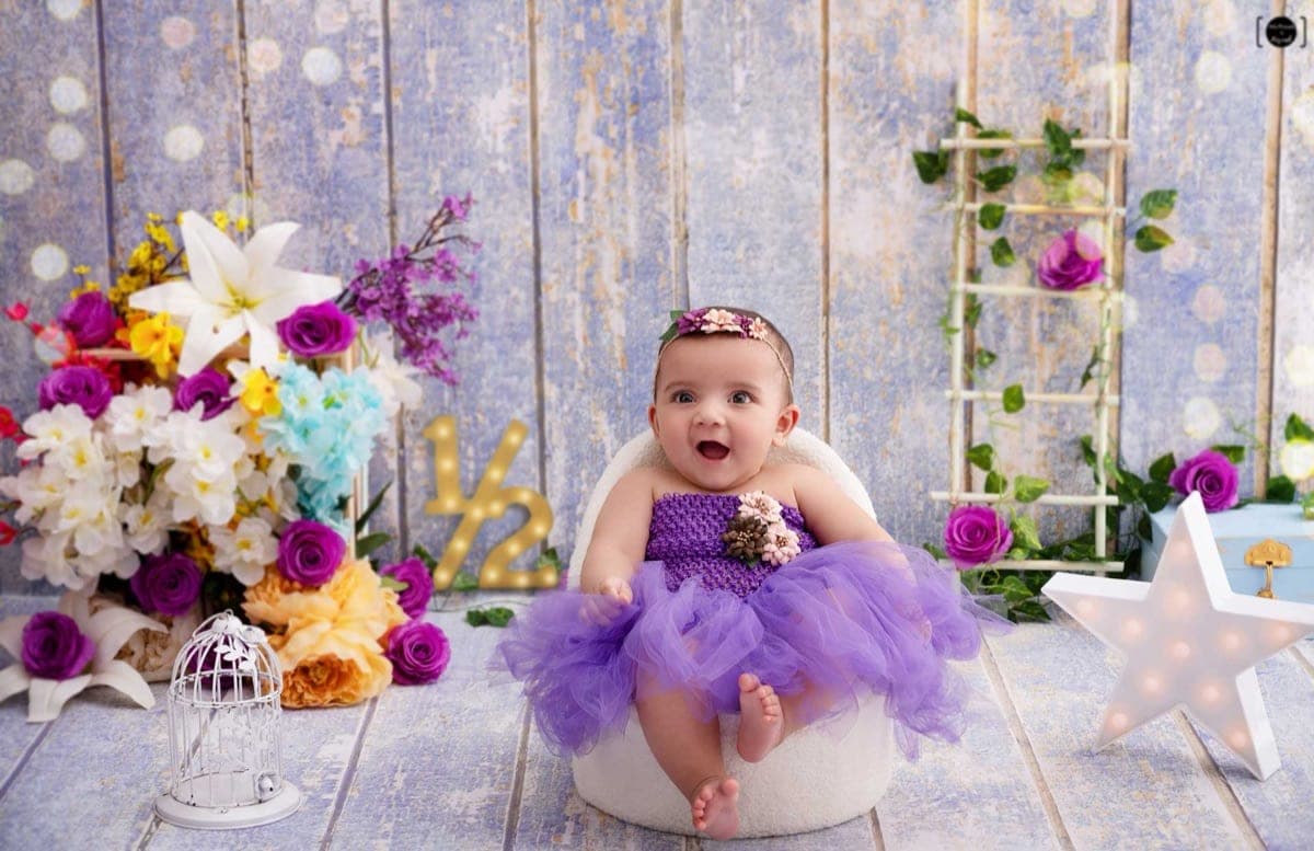Baby playing and smiling during a milestone photography session in Delhi NCR studio by Priyansh Bhardwaj.